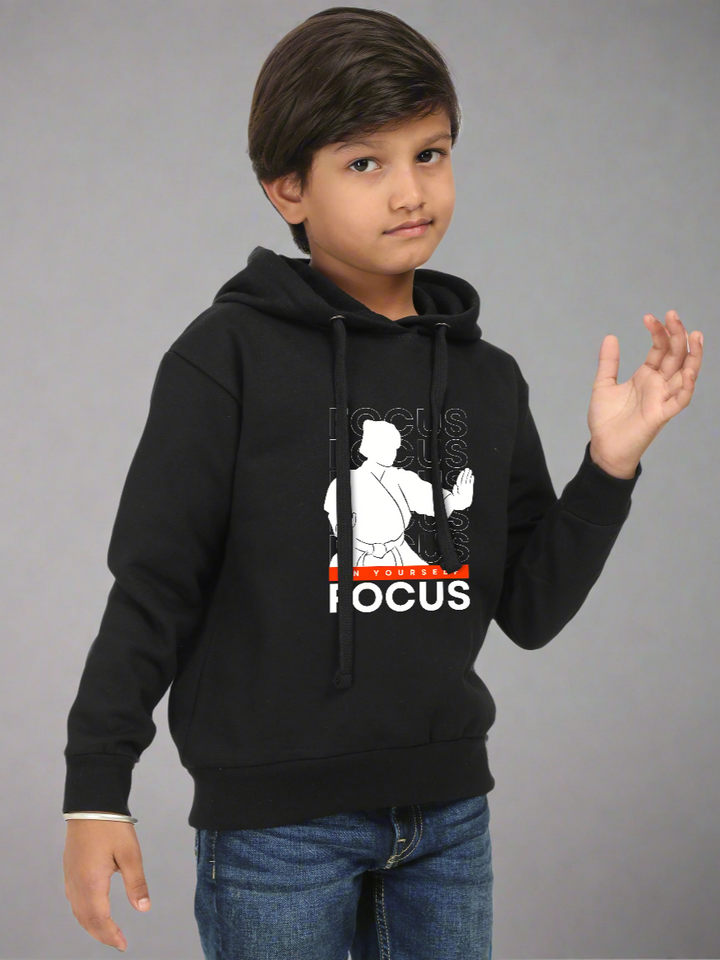 Child wearing a black hoodie with a graphic design on a gray background